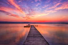 Exciting Sunset At Shore With Wooden Pier And Boat