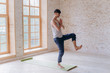 © yuliyalyashok - Relaxed young man doing yoga and meditating in studio