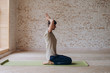 © yuliyalyashok - Relaxed young man doing yoga and meditating in studio