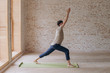 © yuliyalyashok - Relaxed young man doing yoga and meditating in studio
