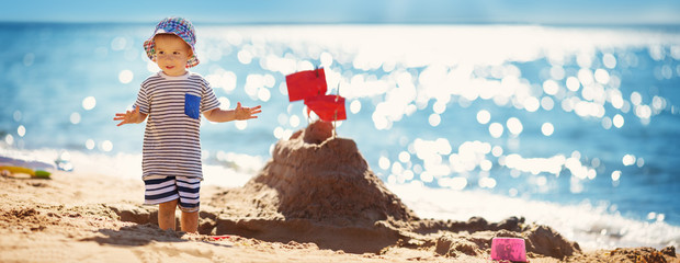 Wall Mural - boy sitting smiling at the beach