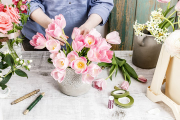 Sticker - Florist at work: woman arranging flowers. Bouquet of pink tulips.