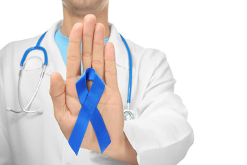 Poster - Doctor with blue ribbon on white background, closeup. Prostate cancer awareness