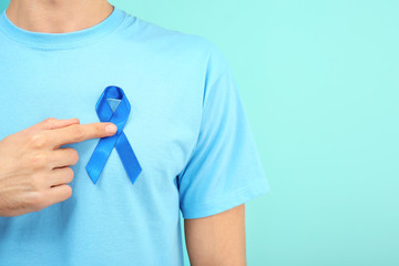 Sticker - Man with blue ribbon on color background, closeup. Prostate cancer awareness