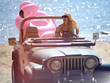 © Dmitry Lobanov - young girl in sunglasses sitting in beach truck car on sunny summer day near sea beach with giant inflatable giant pink flamingo float mattress