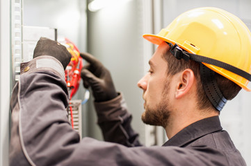 Wall Mural - closeup of electrician engineer works with electric cable wires