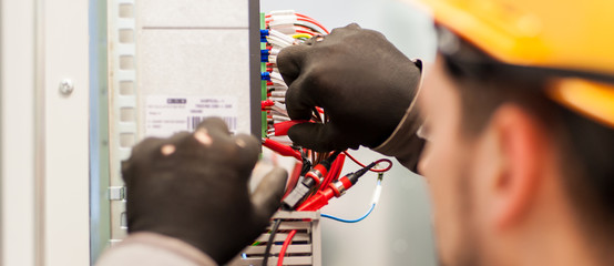 Closeup of electrician engineer works with electric cable wires