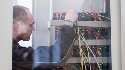 Wall Mural - electrician engineer tests electrical installations on relay protection system