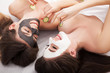 © Maksymiv Iurii - A picture of two girls friends relaxing with facial masks on over white background