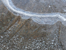 Close-up Of A Frozen Water Puddle On The Ground