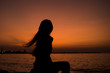 © miraclebuggy - Silhouette of Asia Beautiful girl in quiet nature. There is an orange sunset in the background,copy space