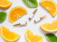 Vitamin C Brown Ampule For Injection With Fresh Juicy Orange Fruit Slices On White Table. High Dose Vitamin C Synthetic For White Skin. Beauty Product Branding Mock-up. Healthy Lifestyle. Top View.