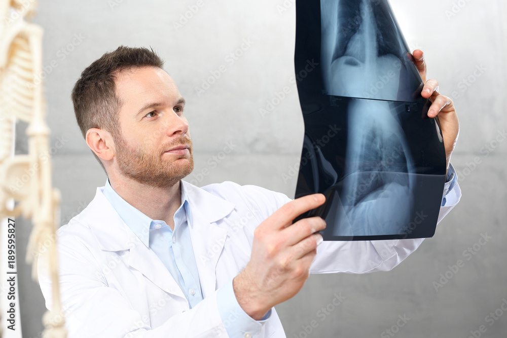 Ortopeda.
Lekarz w gabinecie lekarskim ogląda zdjęcie rentgenowskie pacjenta.
 - obrazy, fototapety, plakaty 