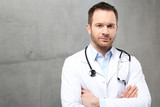Fototapeta  - Lekarz.
Przystojny lekarz ubrany w biały kitel stoi w klinice
