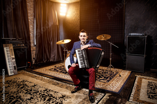 Fotografia, Obraz Accordionist in the recording studio. Accordion on the knee