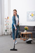 © LIGHTFIELD STUDIOS - attractive woman with vacuum cleaner cleaning room at home