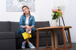 © LIGHTFIELD STUDIOS - tired woman with cleaning supplies in hands resting on sofa at home