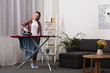 © LIGHTFIELD STUDIOS - attractive woman ironing clothing at home