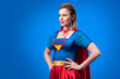 © LIGHTFIELD STUDIOS - portrait of beautiful woman in superhero costume standing akimbo isolated on blue