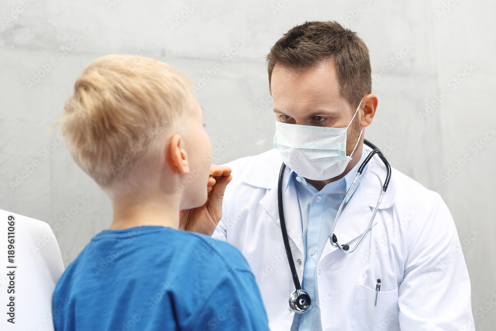 Laryngolog, dziecko u lekarza. Chłopiec w gabinecie lekarza pediatry, badanie lekarskie - obrazy, fototapety, plakaty 