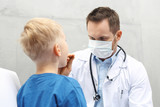 Laryngolog, dziecko u lekarza. Chłopiec w gabinecie lekarza pediatry, badanie lekarskie