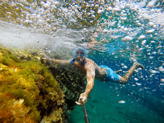 Wall Mural - Man swimming underwater.