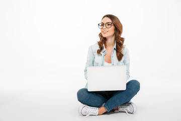 Wall Mural - Portrait of a happy casual girl holding laptop computer