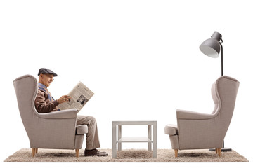 Sticker - Senior sitting in an armchair and reading a newspaper