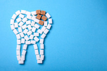 Sugar Destroys The Tooth Enamel And Leads To Tooth Decay. Sugar Cubes Are Laid Out In The Form Of A Tooth And Brown Sugar Symbolizes Caries. Copy Space For Text