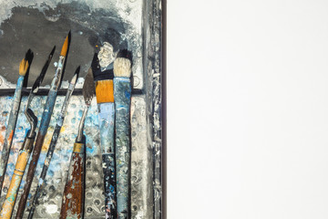 Group of brushes and spatula on a colorful background and white isolated copy space