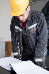 Wall Mural - engineer interprets and looks project plans on relay protection system