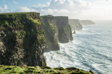 Fototapeta Londyn - The Cliffs of Moher, Irelands Most Visited Natural Tourist Attraction, are sea cliffs located at the southwestern edge of the Burren region in County Clare, Ireland.
