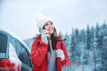 Sticker - Female tourist talking on cellphone in snowy countryside