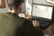 © Teodor Lazarev - Young man using a laptop in his study room, cropped and close up