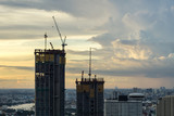 Fototapeta Miasto - Bangkok city - construction of a two high-rise silhouette building with a crane on sunset sky background , cityscape bangkok Thailand