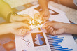 © sunshiro - Team of partner with puzzle piece in hand to join together for teamwork and business success concept.