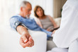 © Halfpoint - Female doctor checking blood pressure of senior man.