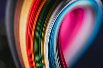 close up of colored bright quilling paper curves on black