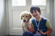 © Emanuele Capoferri - 6 year old boy with his golden retriever puppy dog at home