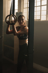 Wall Mural - Woman working out on gymnast rings