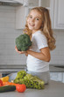 © LIGHTFIELD STUDIOS - smiling kid holding broccoli and looking at camera