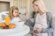 © LIGHTFIELD STUDIOS - daughter rejecting pregnant mothers meal in kitchen
