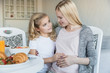 © LIGHTFIELD STUDIOS - daughter touching pregnant mother belly in kitchen