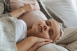 © LIGHTFIELD STUDIOS - cropped image of daughter sleeping on pregnant mother legs
