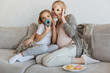 © LIGHTFIELD STUDIOS - happy pregnant mother and daughter covering faces with donuts