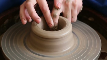 Wall Mural - Process of creating a jar or vase of clay. Woman hands on potter's wheel