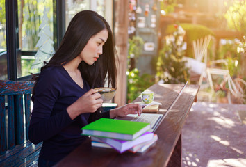 Sticker - woman using laptop at cafe while drinking coffee