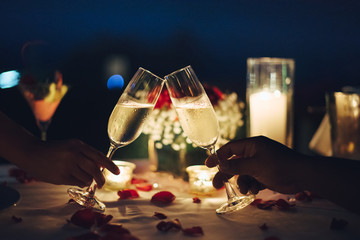 romantic candlelight dinner table setup for couple with beautiful light as background. man & woman h
