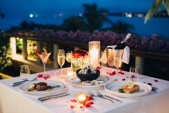 romantic candlelight dinner luxury table setup for couple with beautiful light as background. glasse