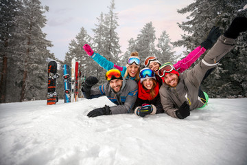 Wall Mural - Enjoying in beautiful winter day- skiers lying on snow and having fun